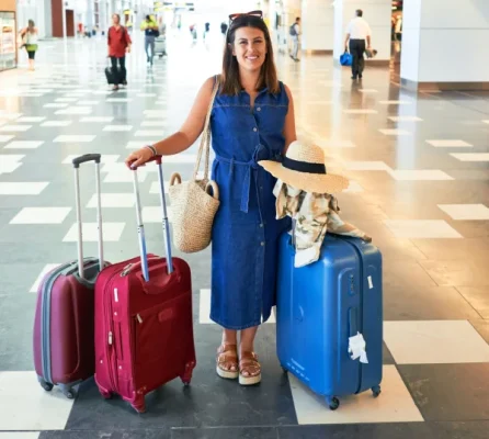 Smiling woman with suitcases after an Airport Transfer
